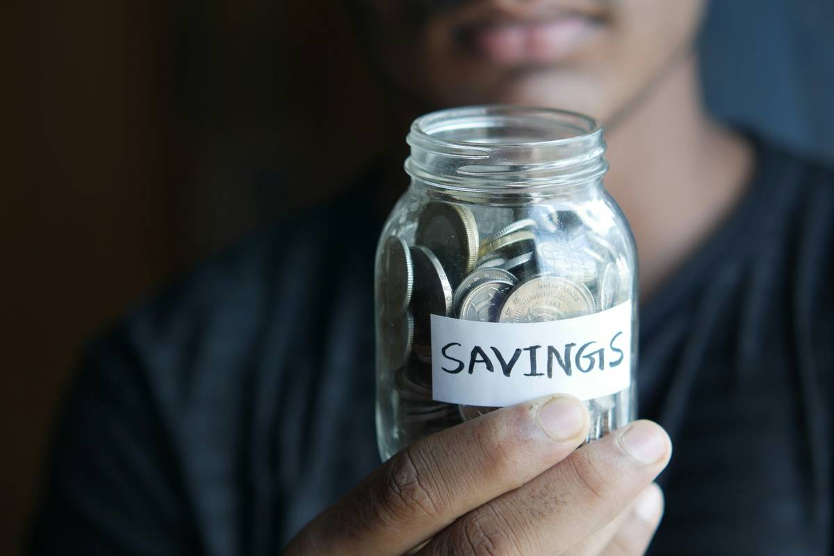 saving hack financial intelligence learn how: person reviewing monthly budget on laptop with calm expression